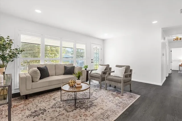 a living room with furniture wooden floor and a large window