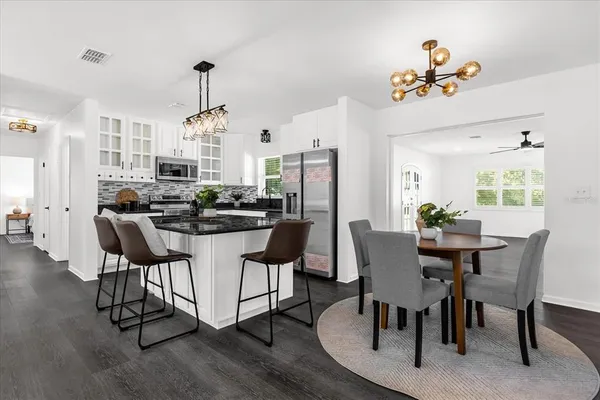 a dining room with furniture a chandelier and wooden floor