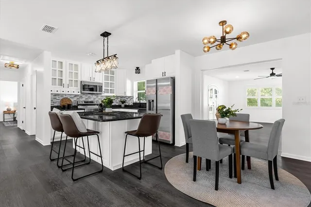 a dining room with furniture a chandelier and wooden floor