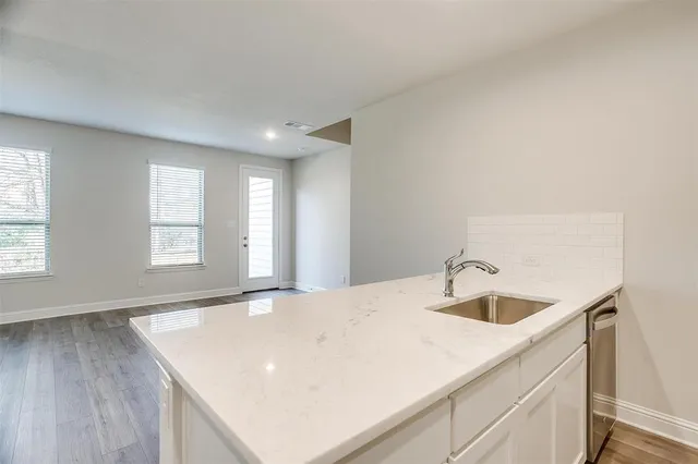 a view of a kitchen island a sink and dishwasher with wooden floor