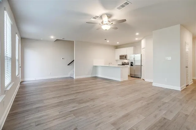 a view of a kitchen with a sink a refrigerator and a window