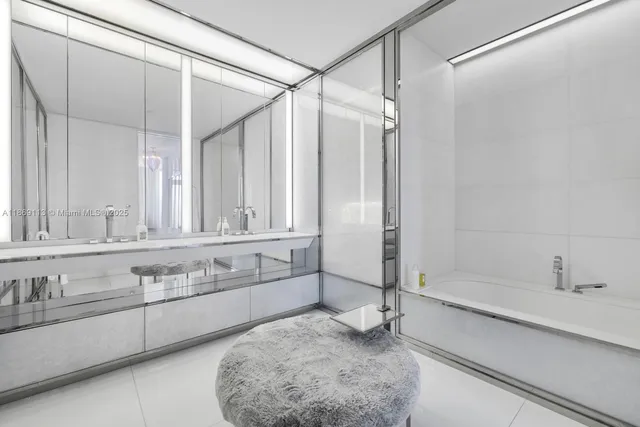 a bathroom with a tub a sink and mirror