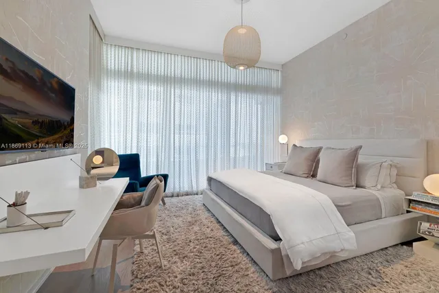 a bedroom with a bed and a flat screen tv