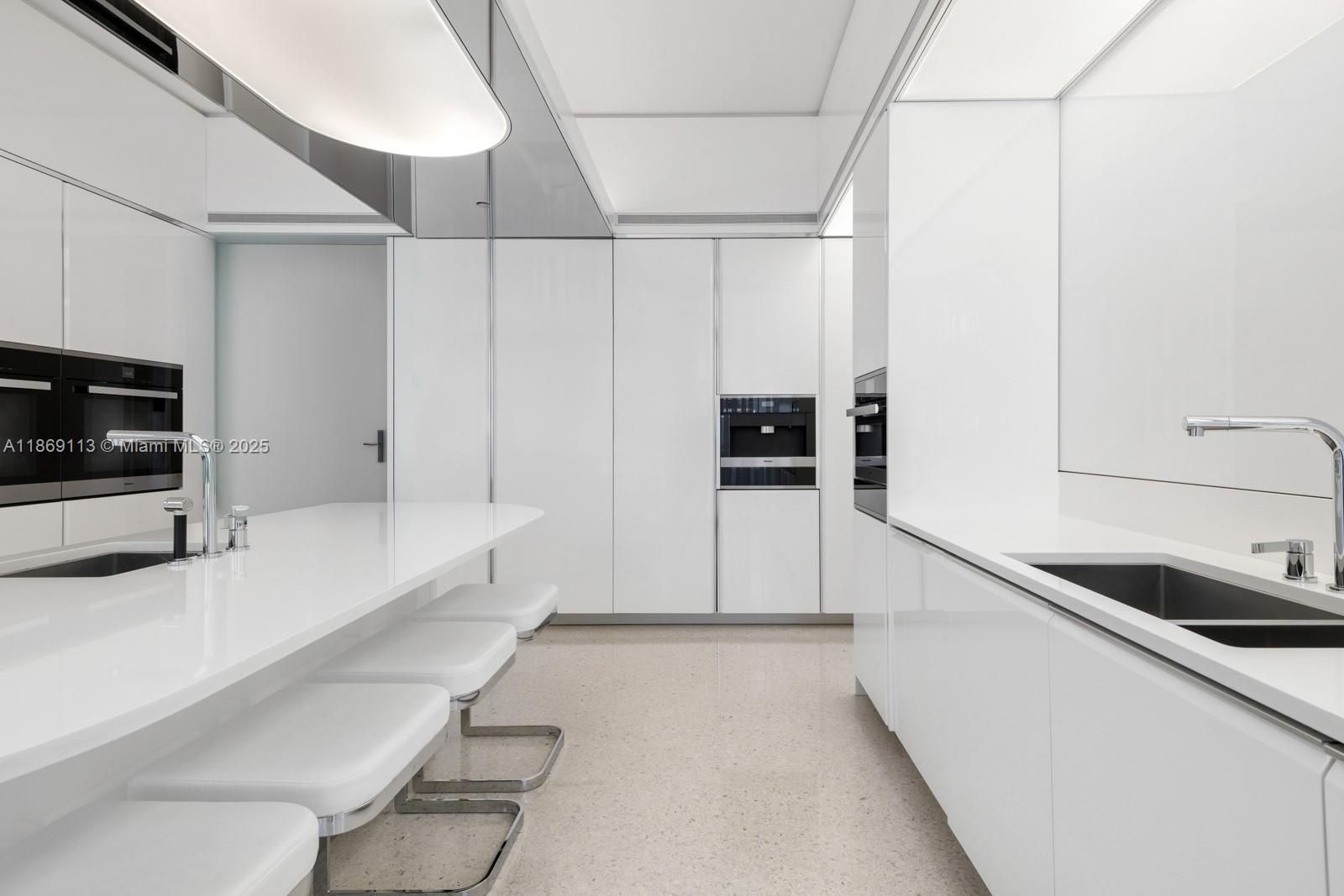 3315 Collins Avenue, Unit 10B Miami Beach, FL 33140 - Photo 6 of 42 a kitchen with stainless steel appliances a sink and a stove top oven