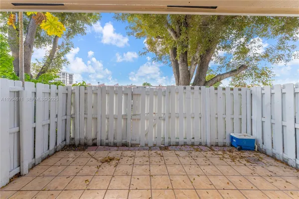 a view of backyard with white fence