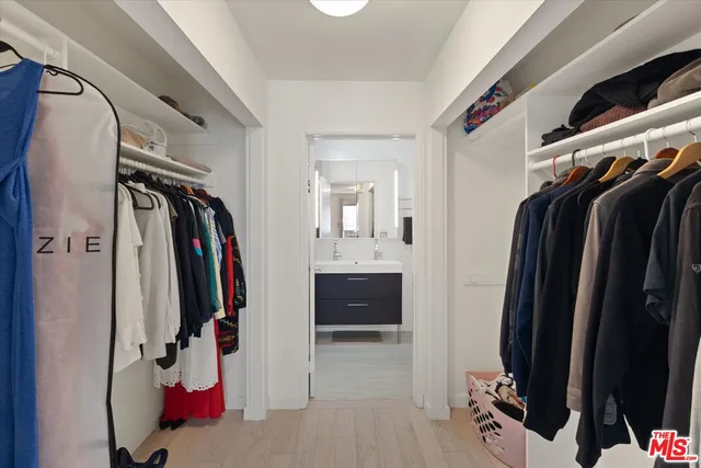 a view of walk in closet with clothes and shoes
