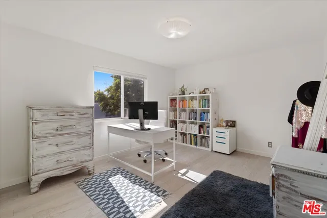a view of a workspace with furniture and a window