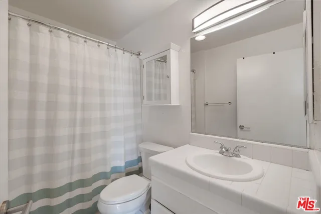 a bathroom with a sink a toilet and shower curtain