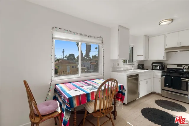 a kitchen with a dining table chairs and white appliances