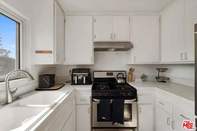 a kitchen with stainless steel appliances granite countertop a sink stove and cabinets