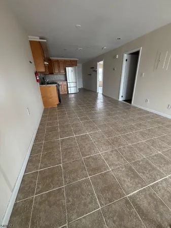 a kitchen with granite countertop a stove a sink and a refrigerator