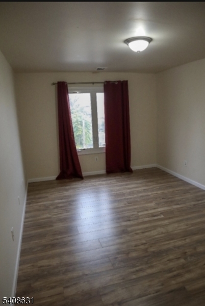 59 Wilson Avenue, Unit 1 Newark, NJ 07105 - Photo 5 of 9 an empty room with wooden floor and windows