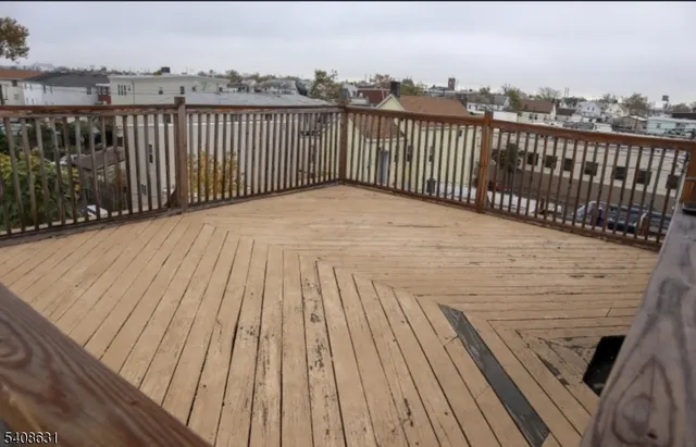 a view of a balcony with wooden floor and fence