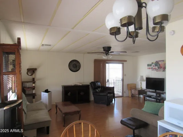 a living room with furniture kitchen view and a flat screen tv