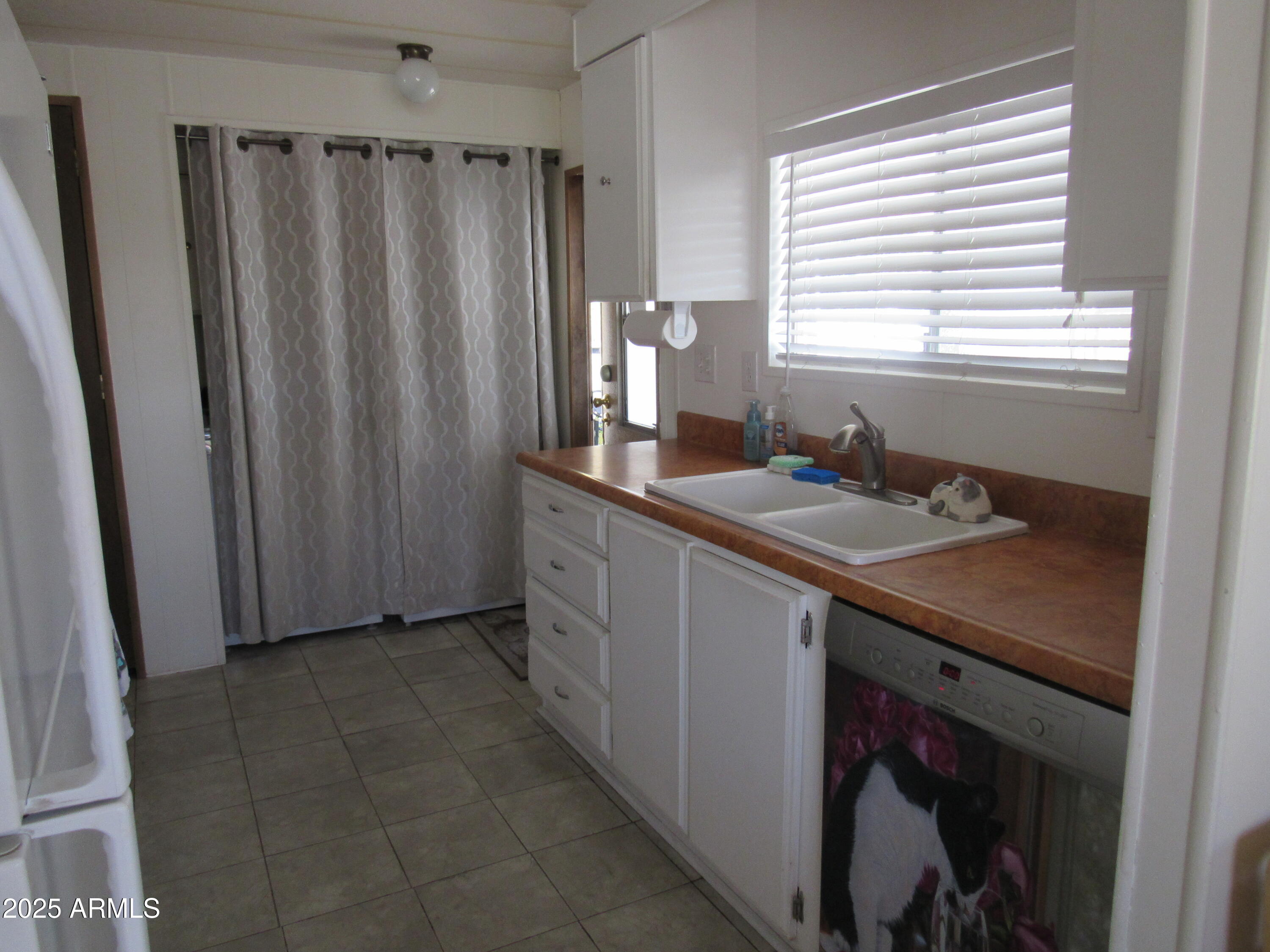 3411 South Camino Seco, Unit 207 Tucson, AZ 85730 - Photo 15 of 25 a kitchen with sink cabinets and window