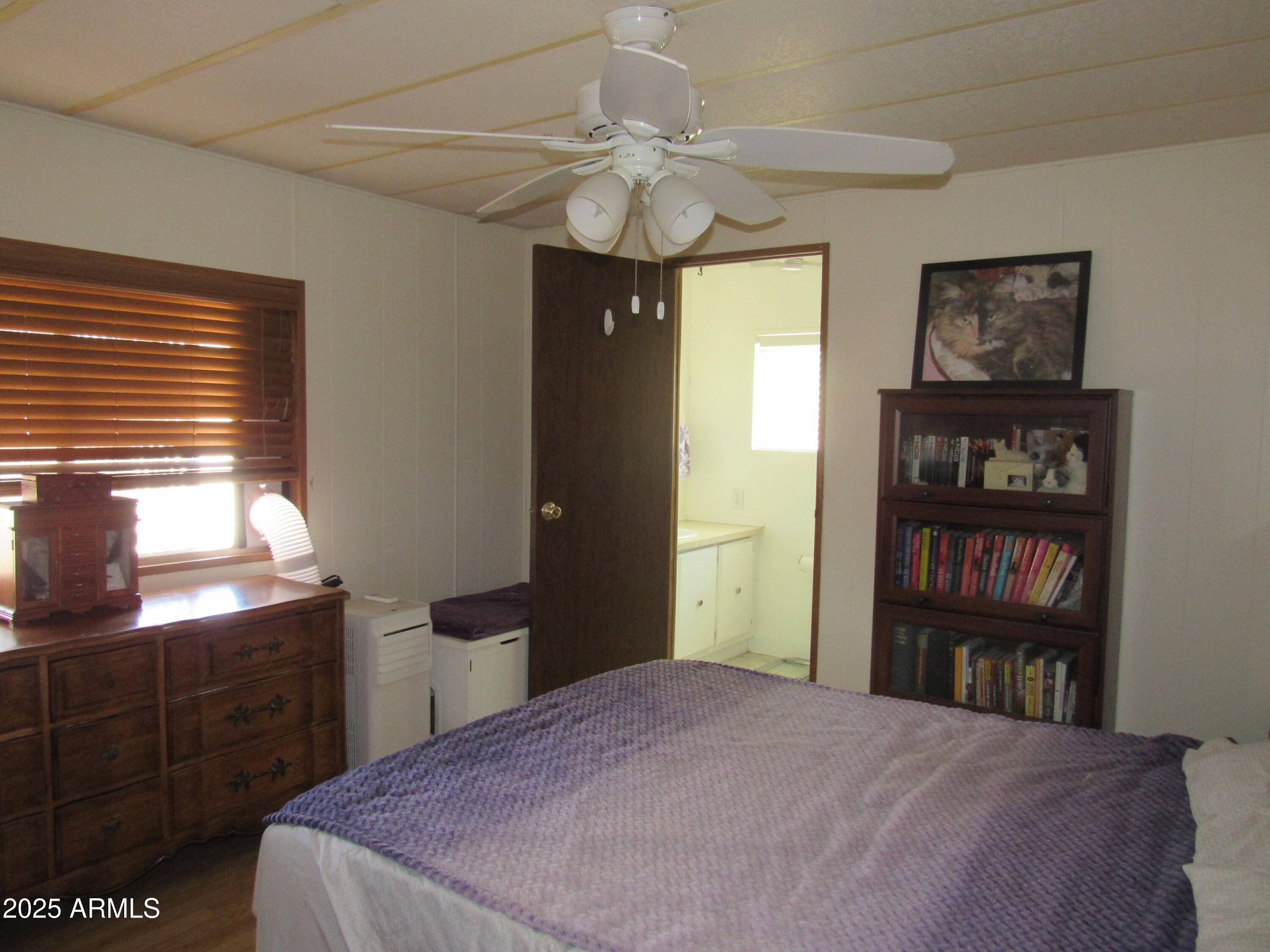 3411 South Camino Seco, Unit 207 Tucson, AZ 85730 - Photo 17 of 25 a bedroom with a bed and a book shelf