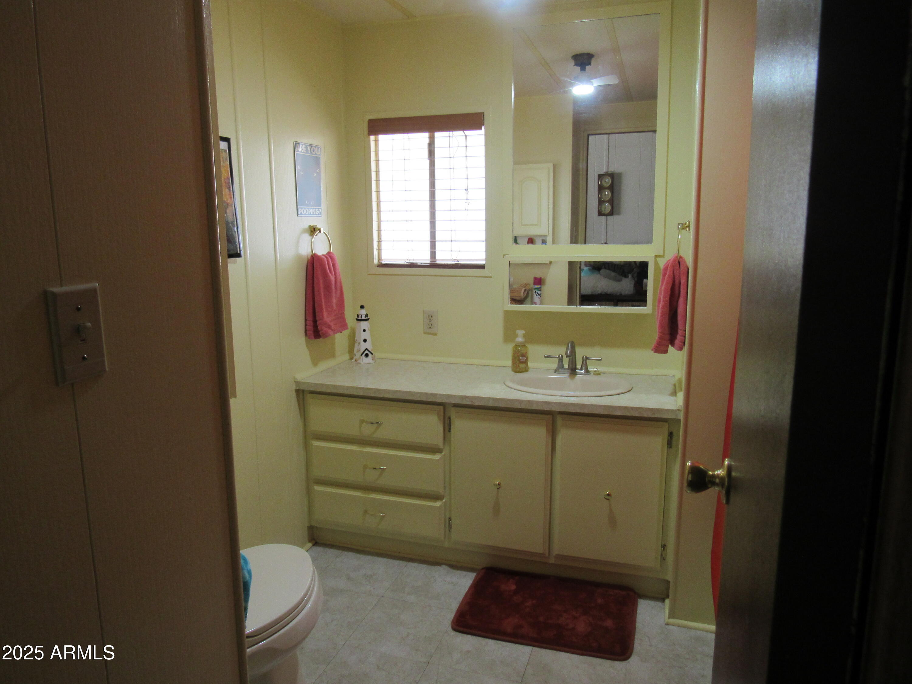 3411 South Camino Seco, Unit 207 Tucson, AZ 85730 - Photo 18 of 25 a bathroom with a toilet sink and mirror