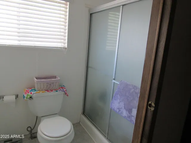 a white toilet sitting next to a bathroom sink and a window