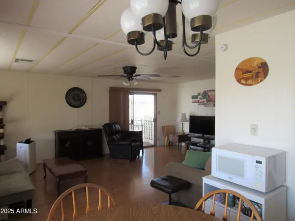 a living room with furniture a chandelier fan and a window