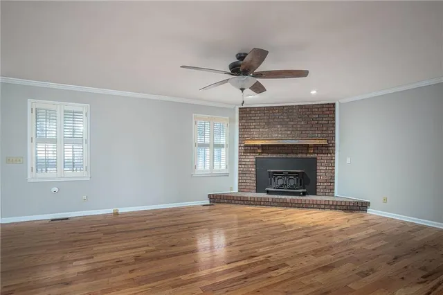 a view of empty room with wooden floor and fireplace