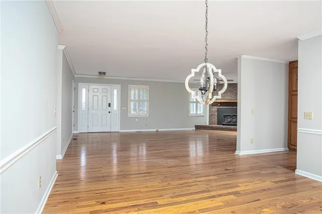 a view of a room with wooden floor and chandelier