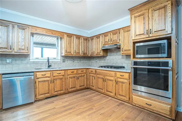 a kitchen with stainless steel appliances granite countertop a stove microwave and cabinets