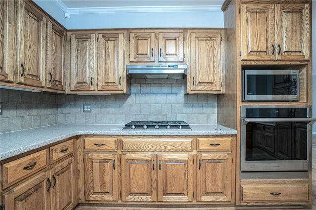 a kitchen with granite countertop white cabinets and stainless steel appliances