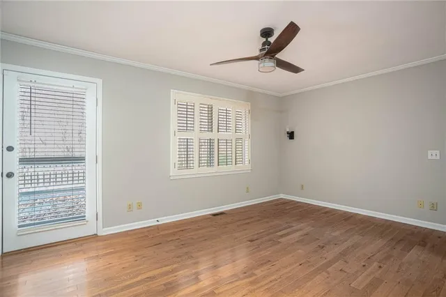 a view of a room with wooden floor and a ceiling fan