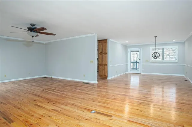 a view of empty room with wooden floor and window