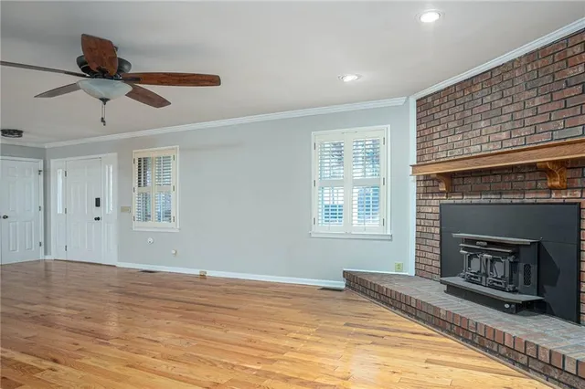 a view of empty room with fireplace and windows