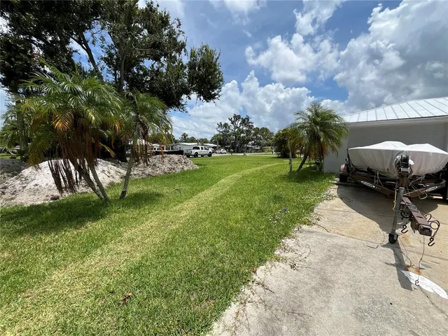 a view of a house with a big yard and a large trees