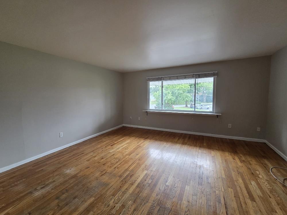 1747 Schoenersville Road Bethlehem, PA 18018 - Photo 2 of 13 An inviting living area with a wide window, offering abundant natural light and rich wood flooring.