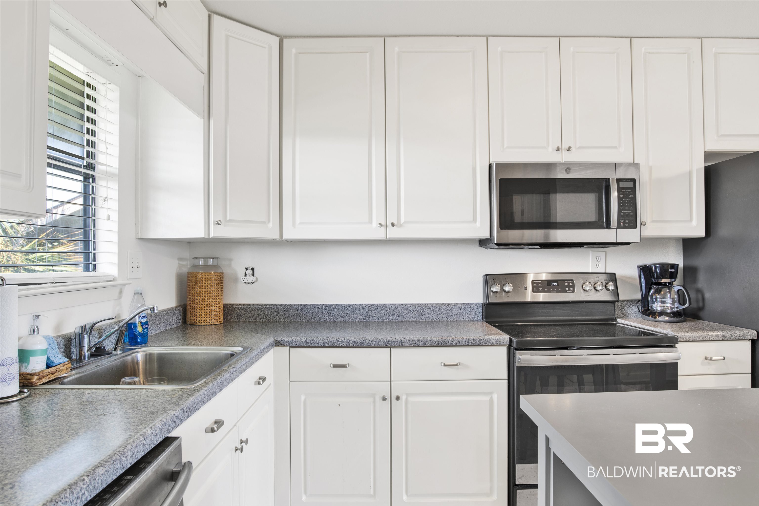 26913 Marina Road, Unit 213 Orange Beach, AL 36561 - Photo 11 of 30 Kitchen featuring stainless steel appliances, white cabinetry, and sink