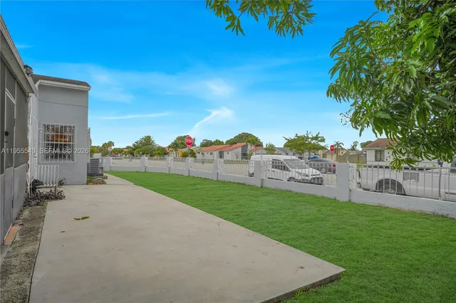 a view of a house with a yard and potted plants