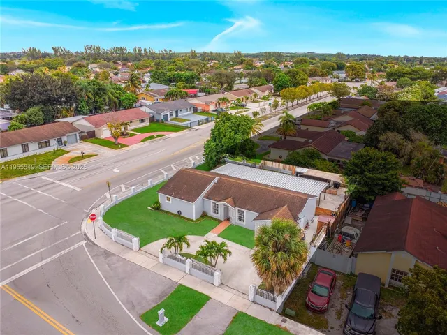an aerial view of a house with a garden and a car parked