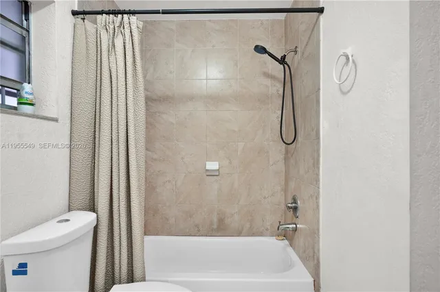 a bedroom with a bed a couch and a flat tv screen