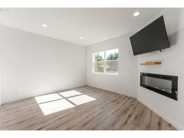 a view of an empty room with a flat screen tv and a window