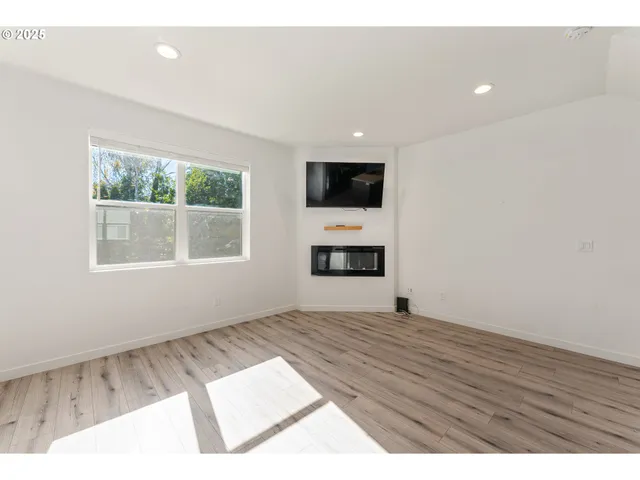 a view of empty room with a flat screen tv and windows