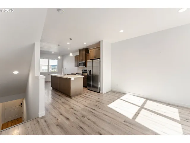 a open kitchen with a sink and a refrigerator