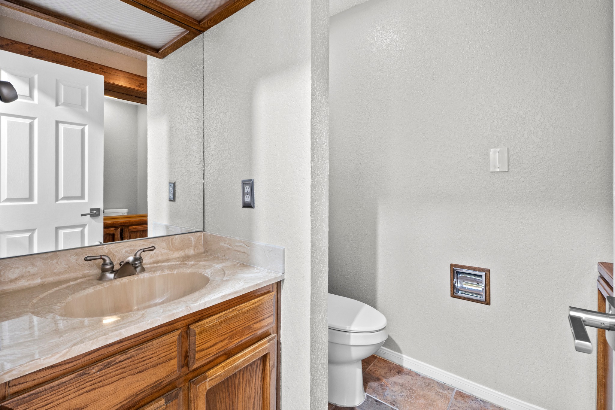 205 Sedro Trail Georgetown, TX 78633 - Photo 25 of 32 Marble vanity with a wood cabinet and a well-lit mirror complements this functional bathroom space.