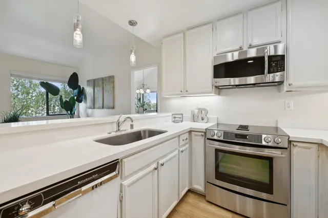 a kitchen with stainless steel appliances a stove a microwave and sink