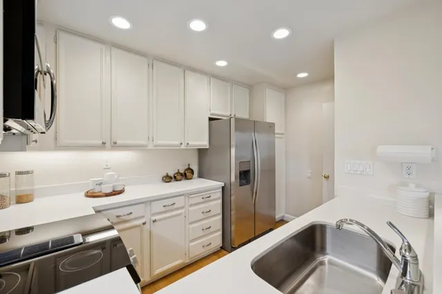 a kitchen with a refrigerator sink and cabinets