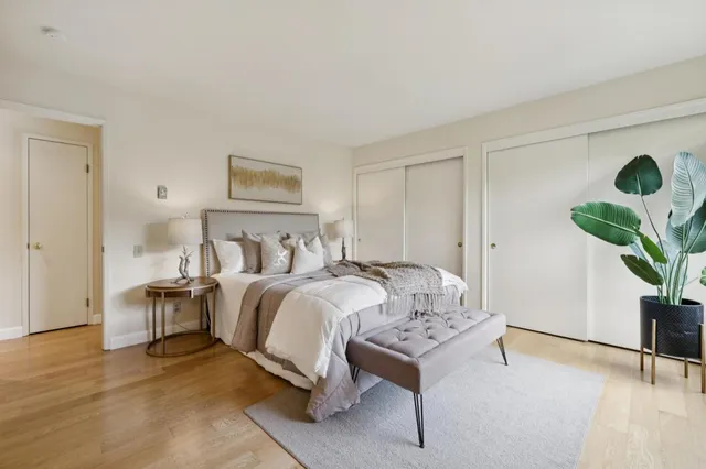 a bedroom with a bed and a potted plant