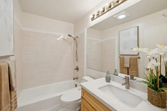 a bathroom with a bathtub shower sink and toilet