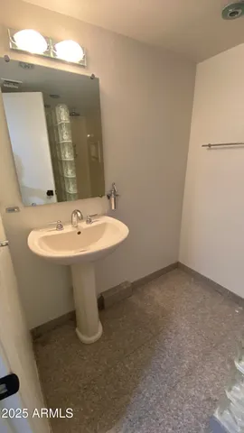 a white sink sitting under a mirror