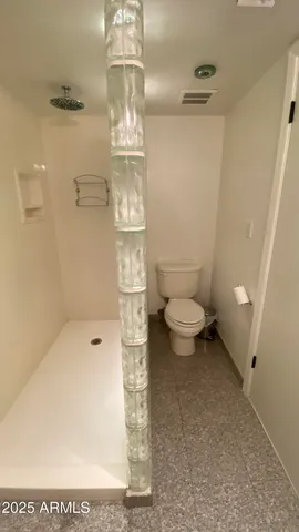 a bathroom with a toilet and a shower