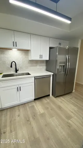 a kitchen with stainless steel appliances a refrigerator a sink a stove and cabinets