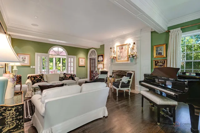 a living room with fireplace furniture and a large window