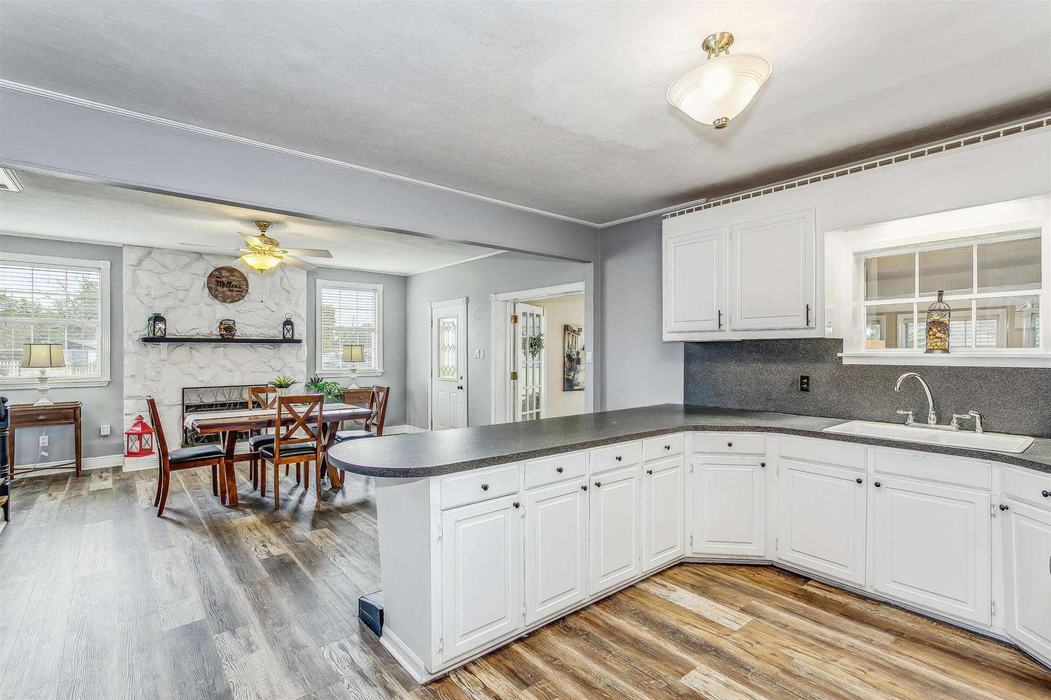 5926 Saufley Pines Road Pensacola, FL 32526 - Photo 11 of 35 a kitchen with a sink stove and white cabinets with wooden floor