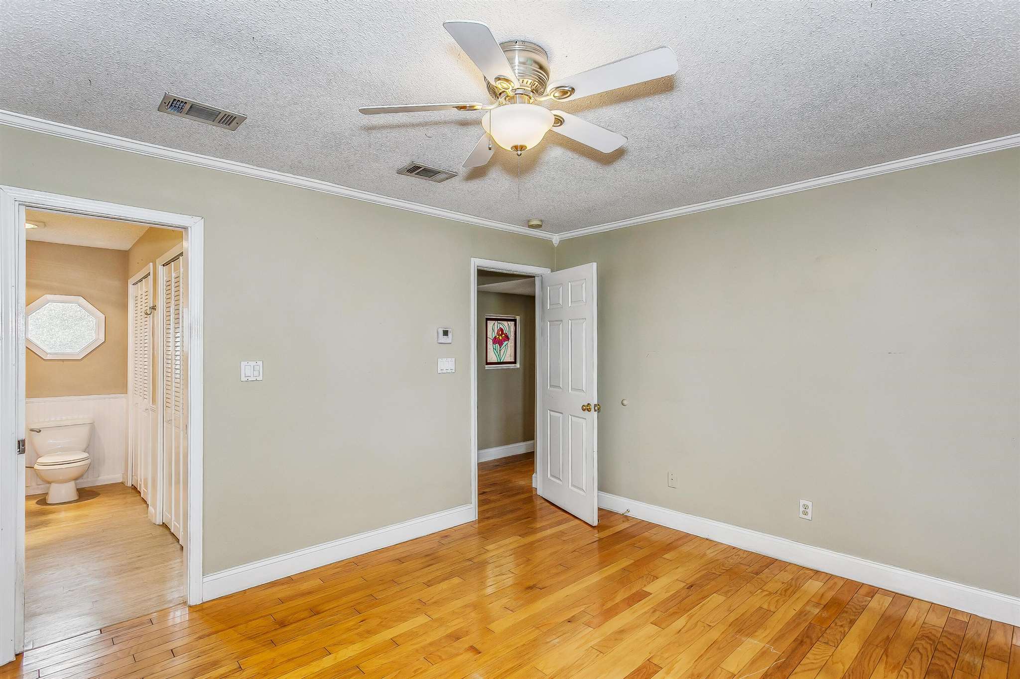 5926 Saufley Pines Road Pensacola, FL 32526 - Photo 20 of 35 a view of an empty room and a bathroom with wooden floor